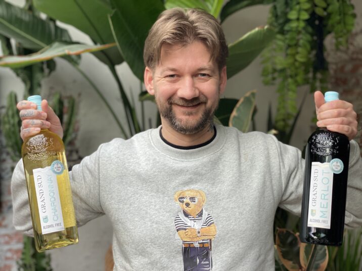 Jan Willem van B4men met een fles Grand Sud alcoholvrije Chardonnay en Merlot