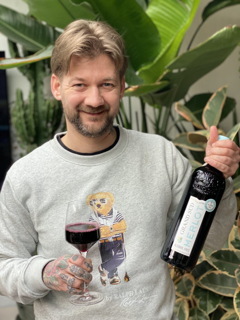 Jan Willem van B4men met een fles Grand Sud alcoholvrije Merlot en een ingeschonken glas