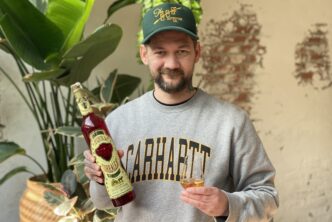 Jan Wille Huffmeijer houd een glas tequila en een fles van Corralejo Añejo tequila