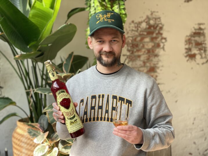 Jan Wille Huffmeijer houd een glas tequila en een fles van Corralejo Añejo tequila