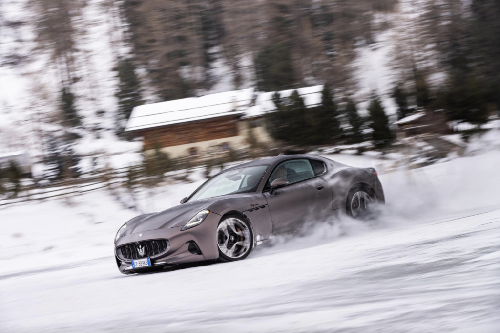 Maserati GranTurismo glijdt dynamisch over het bevroren meer van St Moritz tijdens THE I.C.E. 2025, met besneeuwde bergen op de achtergrond.