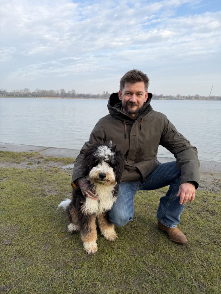 Jan Willem zit bij het water met zijn hond en draagt de PME Legend Rockliner winterjas